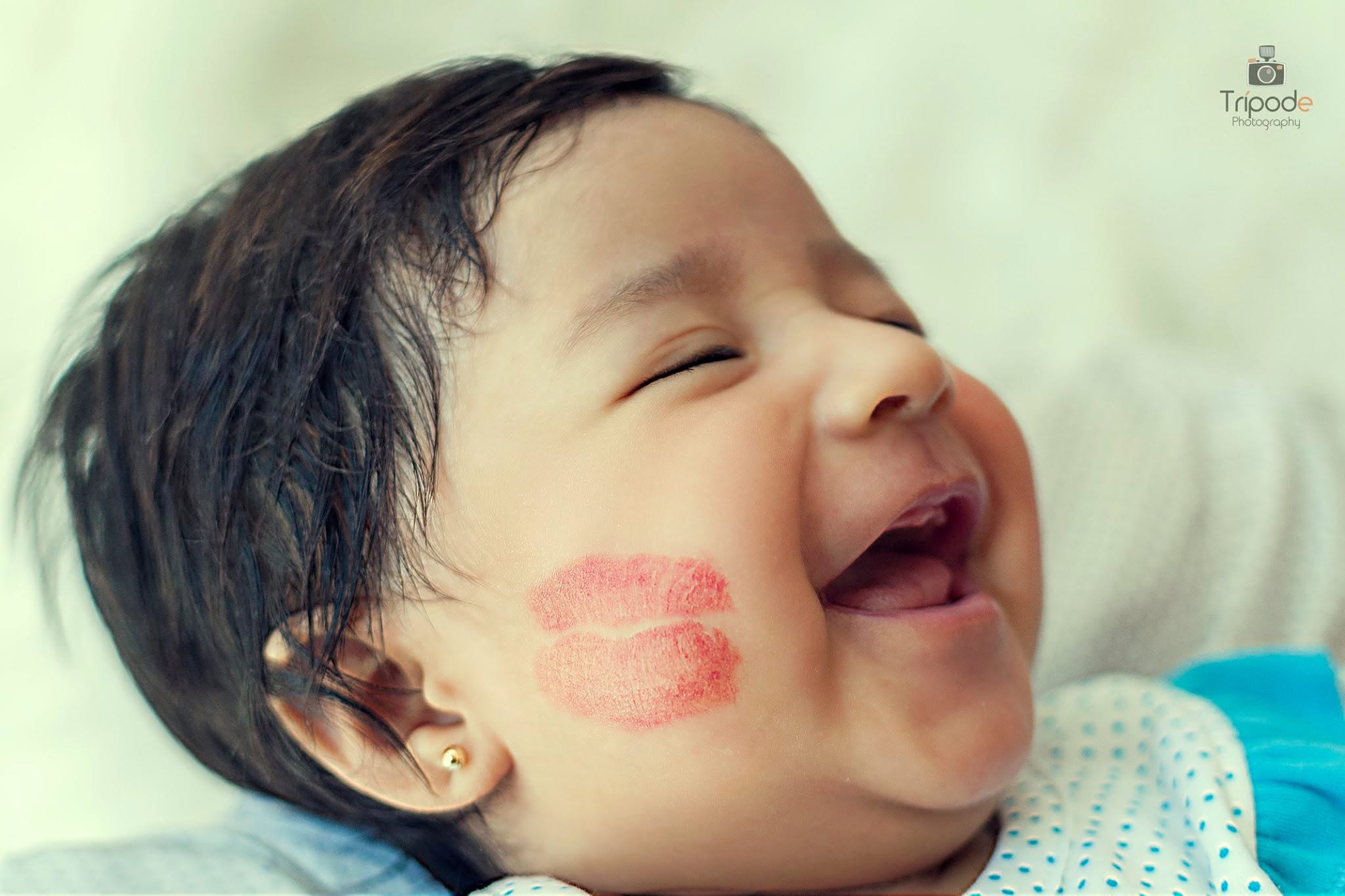 Bebé riendo con marca de beso